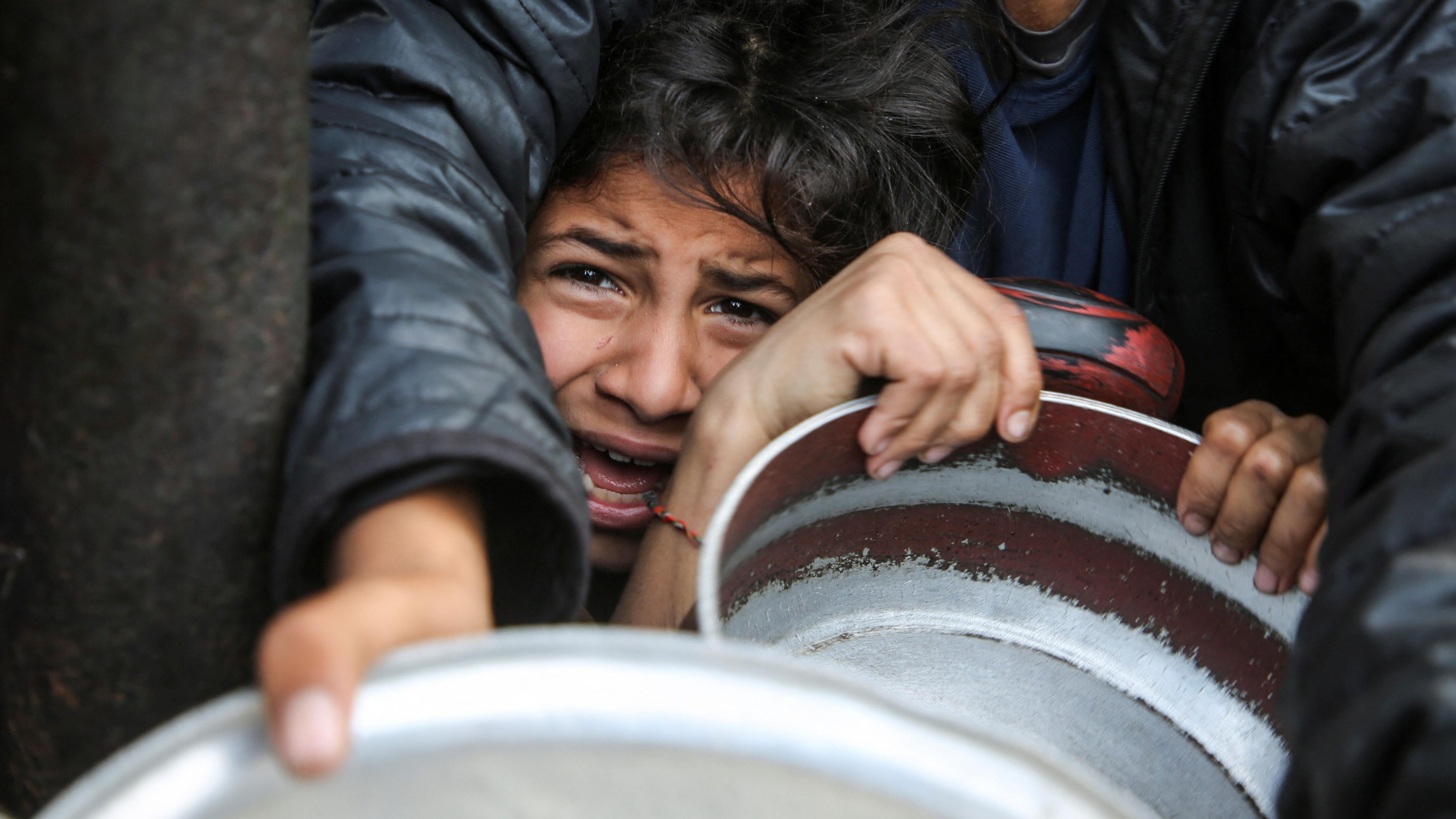 فلسطينيون يتجمعون لتلقي الطعام المطهو في مطبخ خيري في خان يونس جنوب قطاع غزة - Reuters