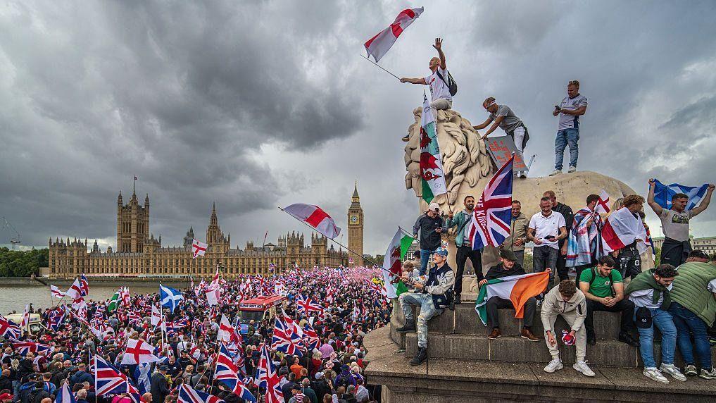 متظاهرون يلوحون بأعلام بريطانية خلال مسيرة على جسر وستمنستر بجوار مبنى البرلمان في 13 سبتمبر/أيلول 2025 في لندن، إنجلترا
 - Getty Images