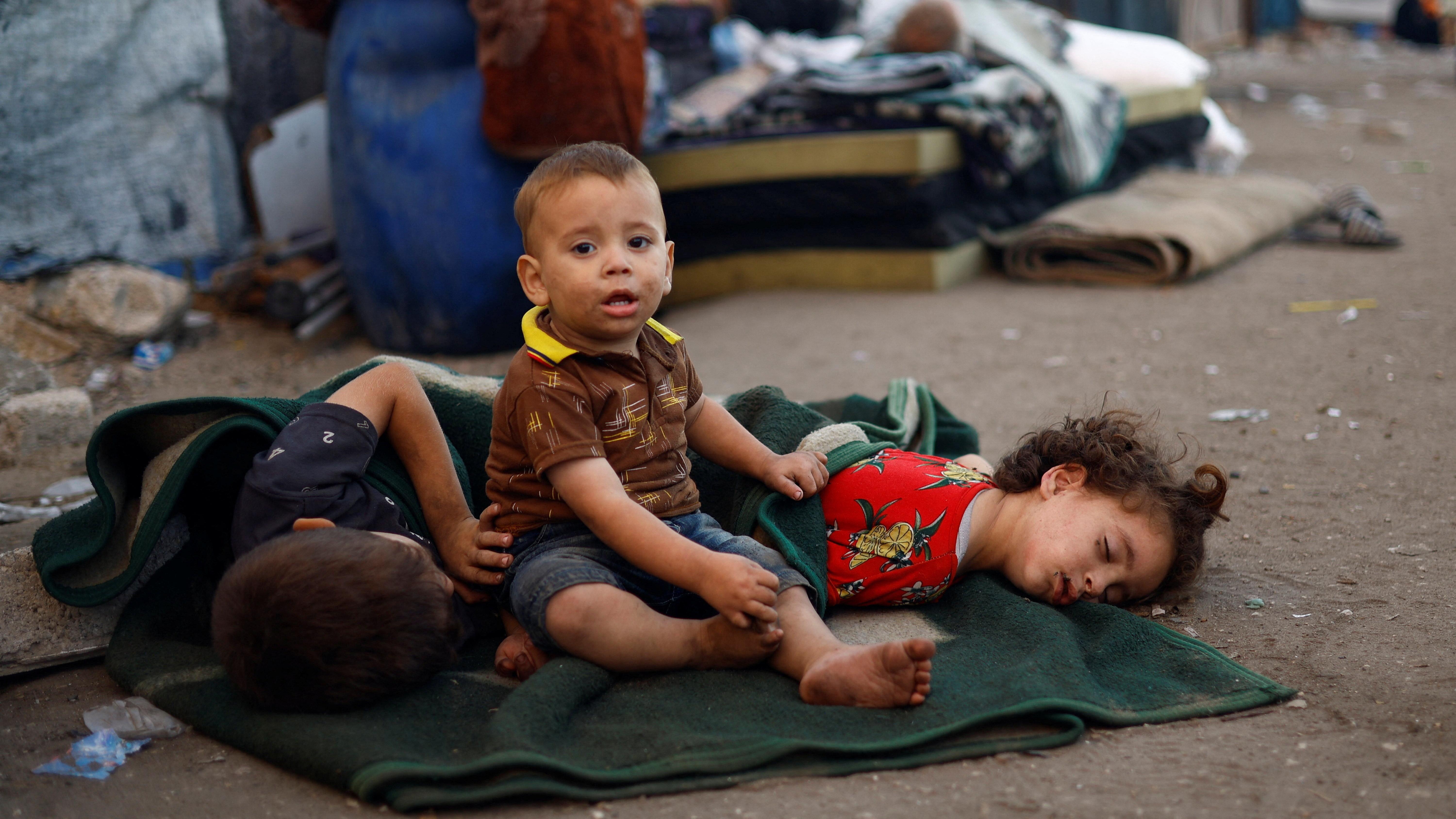 أطفال من بين النازحين الفلسطينيين الفارين من شمال غزة بسبب العملية العسكرية الإسرائيلية يستريحون في طريقهم بينما يتجهون مع آخرين جنوبًا بعد أن أمرت القوات الإسرائيلية سكان مدينة غزة بالإخلاء إلى الجنوب. - Reuters