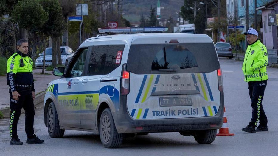 فردان من قوات الأمن التركية يقفان بجوار سيارة شرطة تغلق الشارع أثناء تنفيذ مداهمة أمنية في يالوفا - Reuters