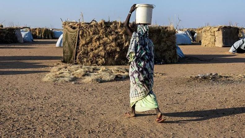 لاجئة سودانية تسير بين خيام مخيم أوري كاسوني بتشاد، في نوفمبر/تشرين الثاني الماضي. - AFP via Getty Images
