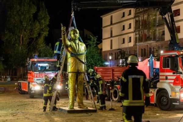 رجال إطفاء يزيلون تمثالًا لأردوغان من إحدى ساحات فيسبادن في غرب ألمانيا، الأربعاء 29 أغسطس 2018 بعد يومين على وضعه ضمن مهرجان بيينالي للفنون