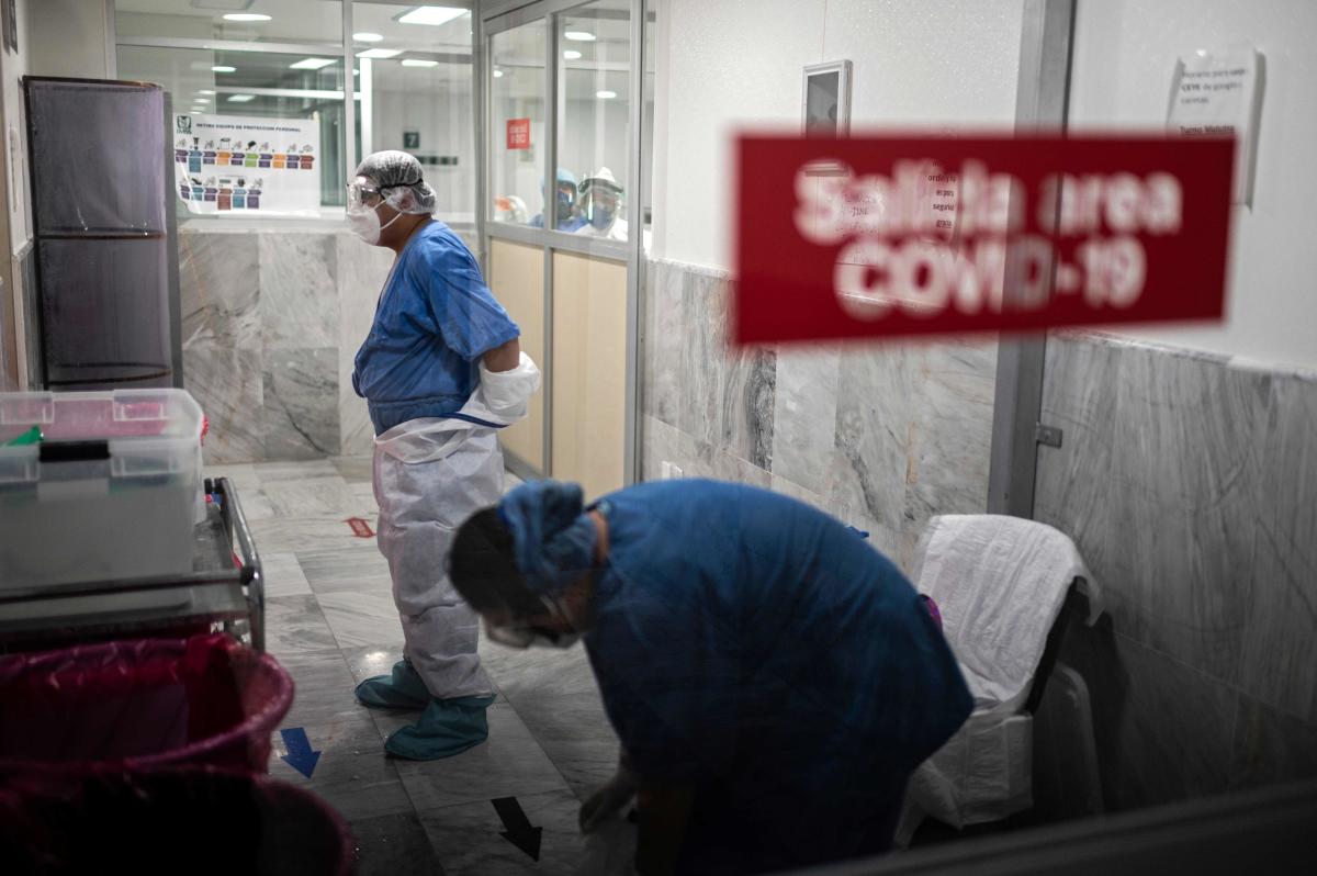عاملان صحيان يخلعان الألبسة الواقية بعد انتهاء عملهما في إحدى مستشفيات مكسيكو سيتي