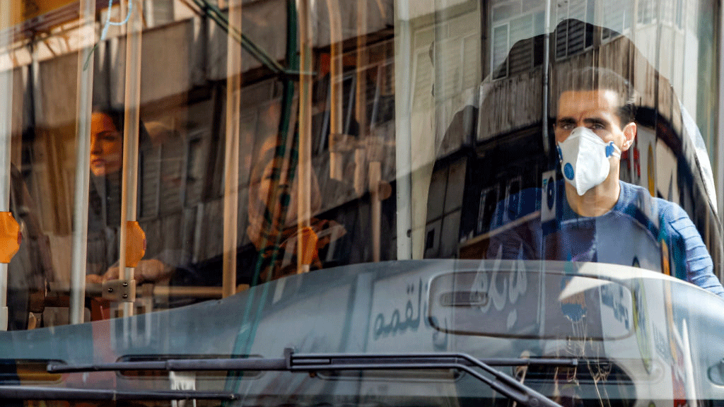 سائق حافلة في إيران يرتدي الكمامة الواقية
