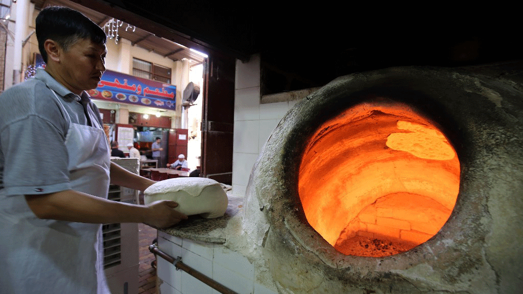 الكثير من الوظائف يعكف المواطنون عن ممارستها، وفي الصورة خباز أمام فرن تقليدي في مخبز في الكويت العاصمة، في 27 يونيو 2019