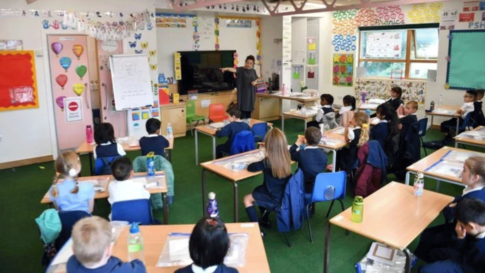 معلمة تتحدث إلى تلاميذها في أول يوم دراسي السنة في إحدى مدارس شرق لندن