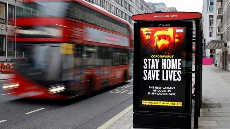 شاشة رقمية في محطة للحافلات وسط لندن تحث المشاة على الوقاية من سلالة كورونا الجديدة بالتزام التدابير التي فرضتها الحكومة.