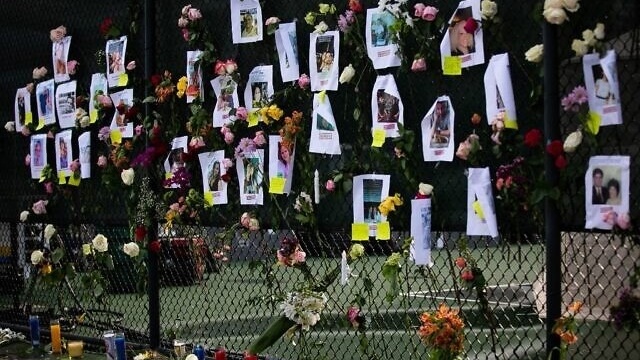 صور المفقودين في المبنى الذي انهار في فلوريدا وقد علقت على سياج في حديقة المدينة في 27 حزيران/ يونيو