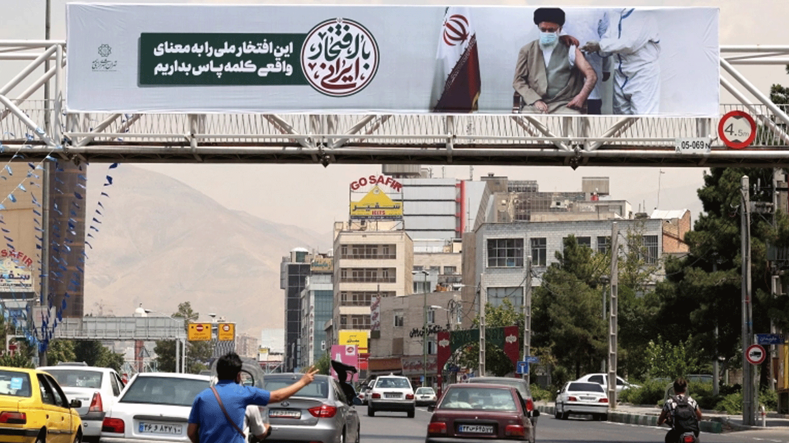 لافتة في شارع في إيرن تُظهر المرشد الأعلى علي حسيني خامنئي وهو يتلقى لقاح كوفيد. 20 تموز/ يوليو 2021