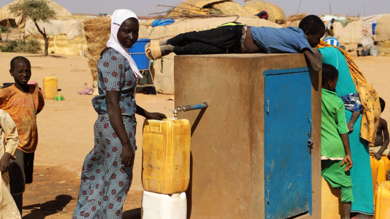 قرويون يقومون بتعبئة مياه الشرب من خزان مشترك في غرب النيجر.