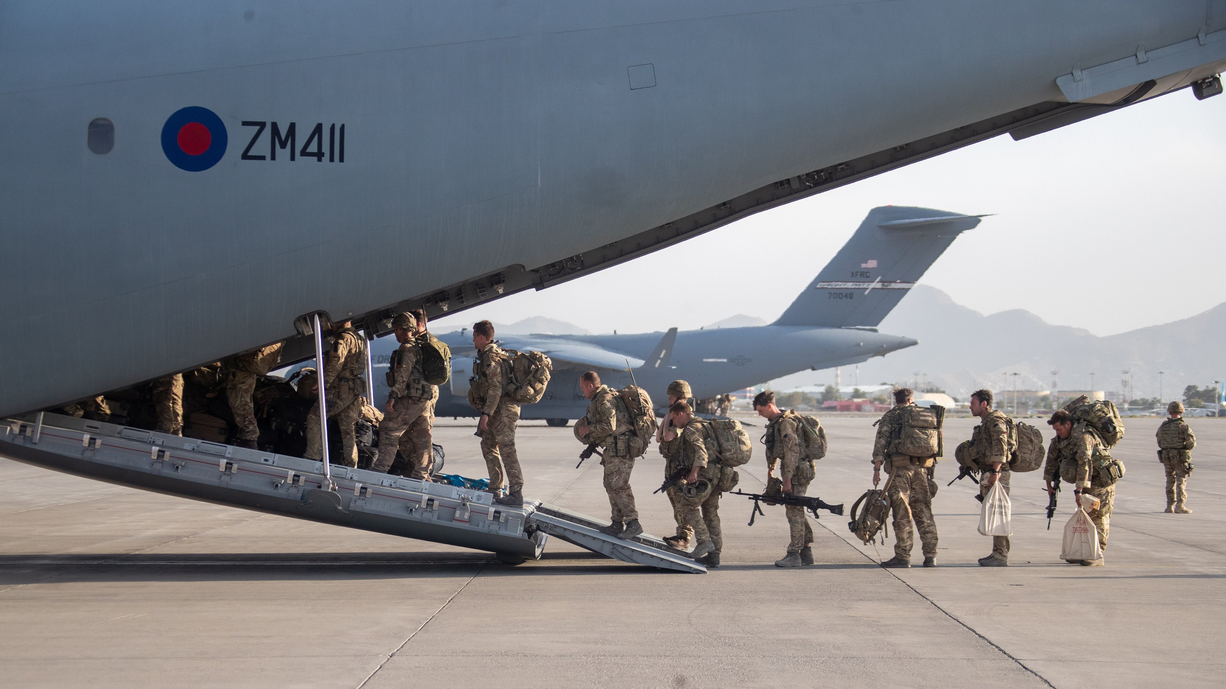 صورة لوزارة الدفاع البريطانية لجنو يصعدون على الطائرة في طريق العودة 