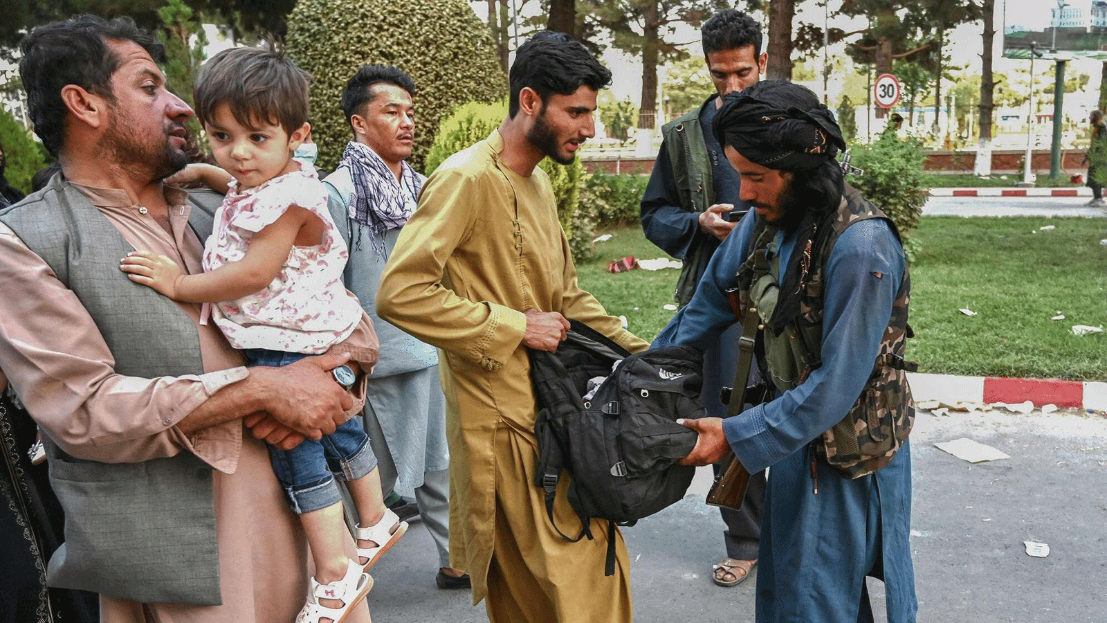 مقاتل من طالبان يفتش حقائب الأشخاص القادمين من مطار كابول. أفغانستان في 16 آب/ أغسطس 2021