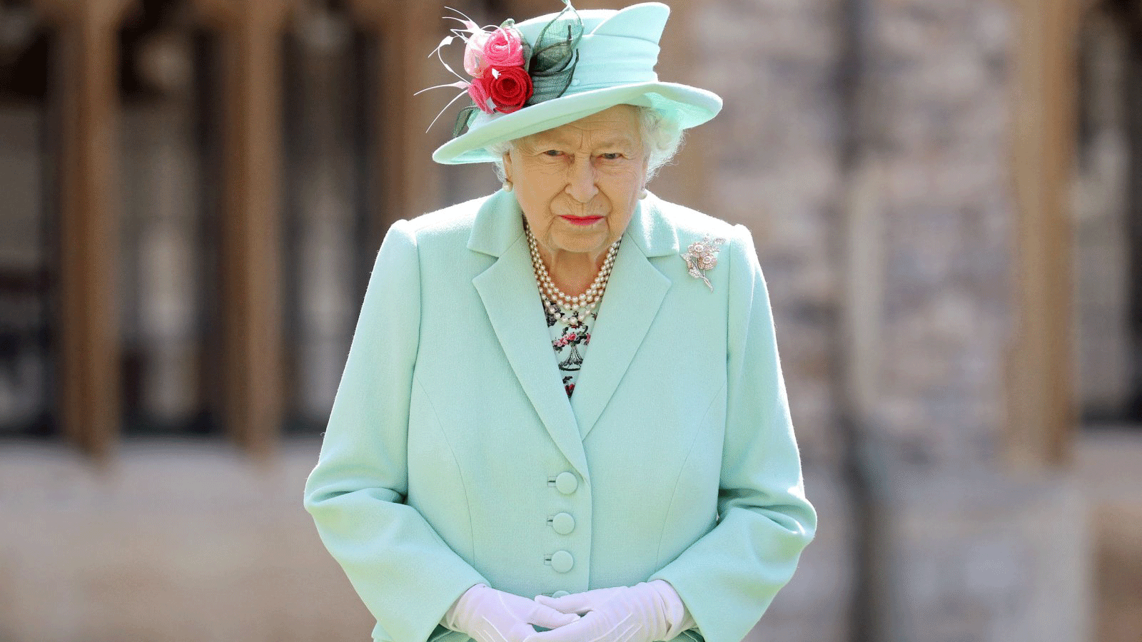 ملكة بريطانيا إليزابيث الثانية تقف بعد منح شرف وسام الفروسية للكابتن المخضرم توم مور البالغ من العمر 100 عام أثناء تنصيبه في قلعة وندسور في المملكة المتحدة. 17 تموز/ يوليو 2020