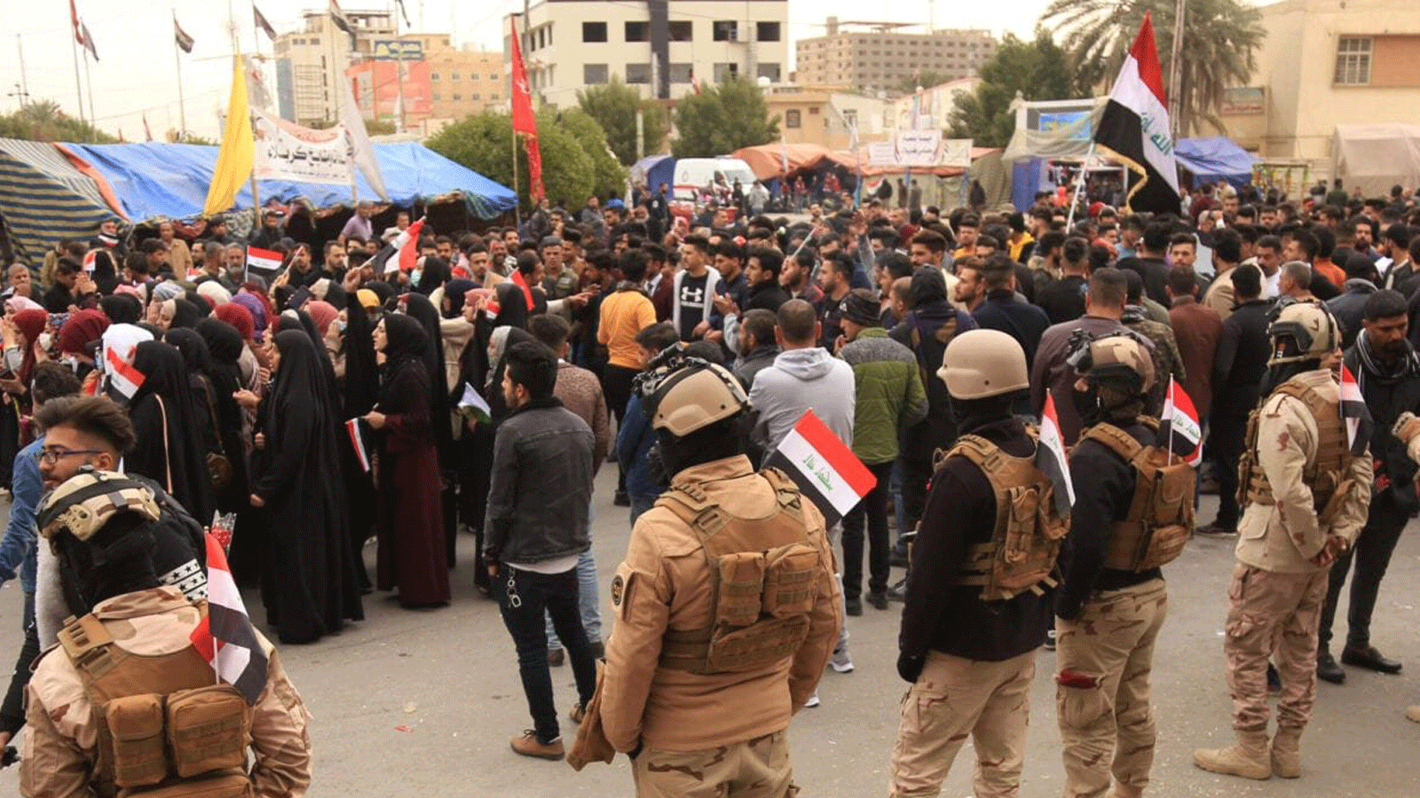 قوات الأمن العراقية تقف بجانب المتظاهرين في مدينة كربلاء الشيعية العراقية ، جنوب العاصمة بغداد ، في 9 فبراير / شباط 2020 
