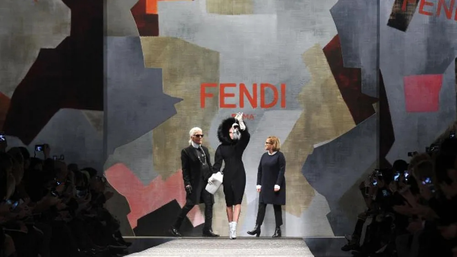 المصممان كارل لاغرفيلد (يسار) وسيلفيا فينتوريني فيندي (يمين) يحيون الجمهور في نهاية عرض مجموعة فندي، بطائرة بدون طيار فوق المنصة، في ميلانو