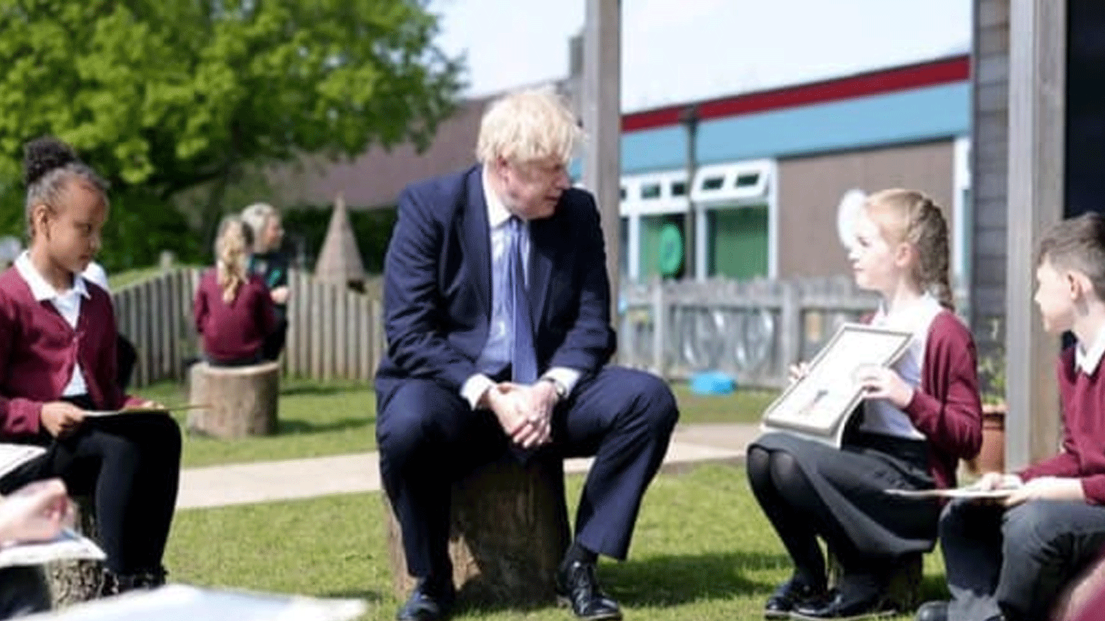 جونسون متحدثا مع عدد من الطلاب في حديقة مدرستهم - صورة من 10 داونينغ ستريت