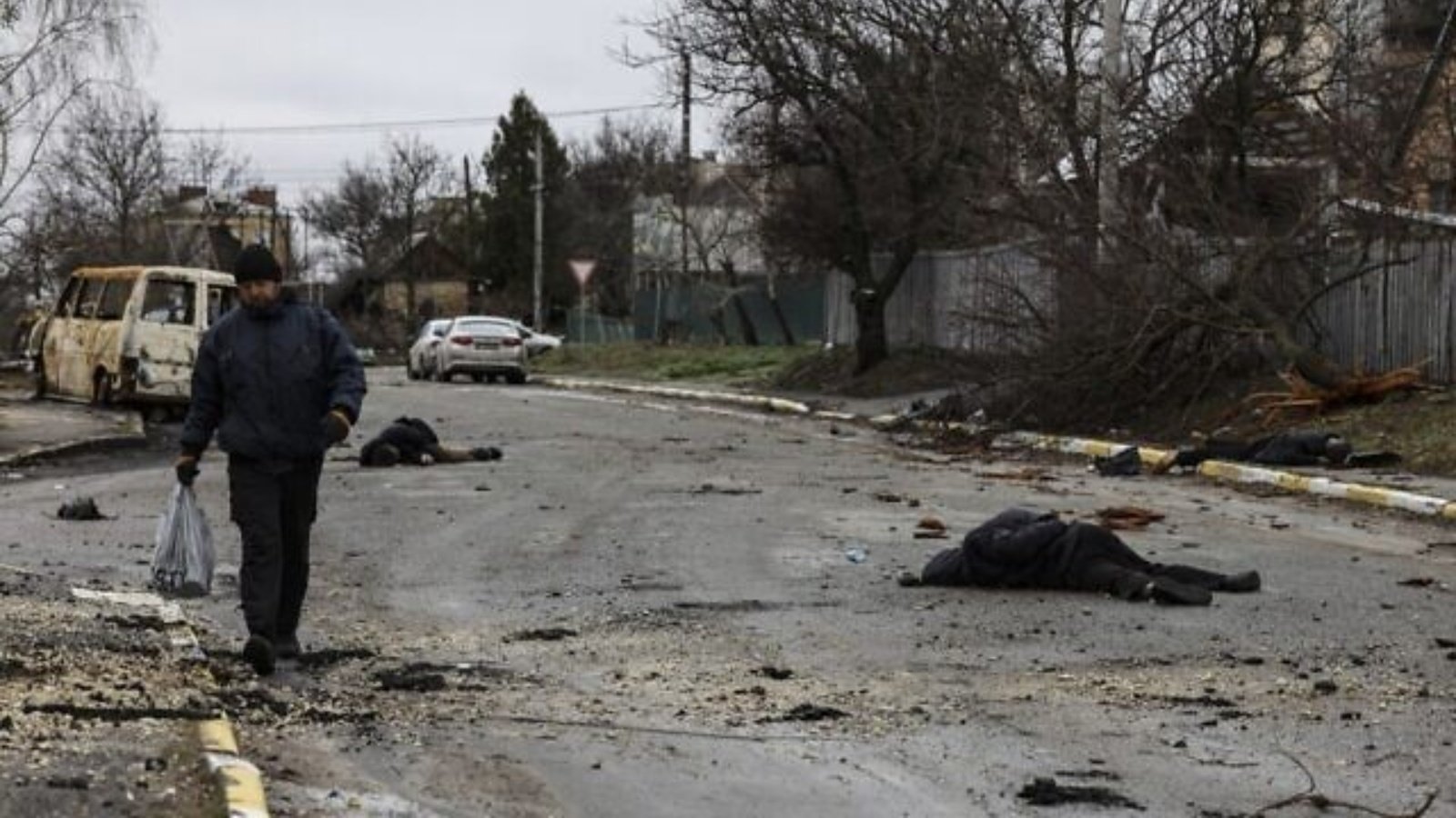 رجل يسير في أحد الشوارع مع العديد من الجثث على الأرض في بوتشا، شمال غرب كييف، أوكرانيا، في 2 أبريل 2022