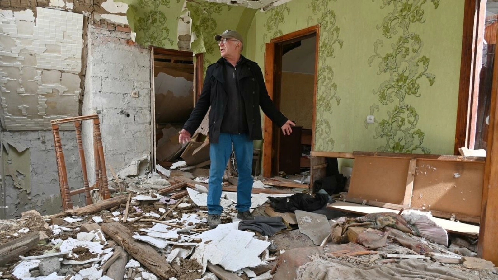رجل بين أنقاض منزله في قرية مالا روغان إلى شرق خاركيف في أوكرانيا في 15 مايو 2022
