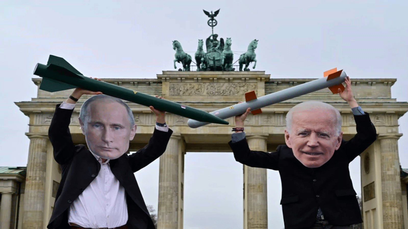نشطاء يرتدون أقنعة الرئيس الروسي فلاديمير بوتين والرئيس الأمبركي جو بايدن يقفون مع صواريخ نووية وهمية أمام بوابة براندنبورغ في برلين في 29 كانون الثاني\ يناير 2021.