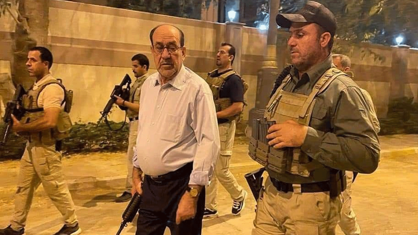 المالكي حاملاً سلاحه يحيط به حراسه لدى اقتحام أنصار الصدر للمنطقة الخضراء وسط بغداد في 27 يوليو\تموز 2022 (تويتر)