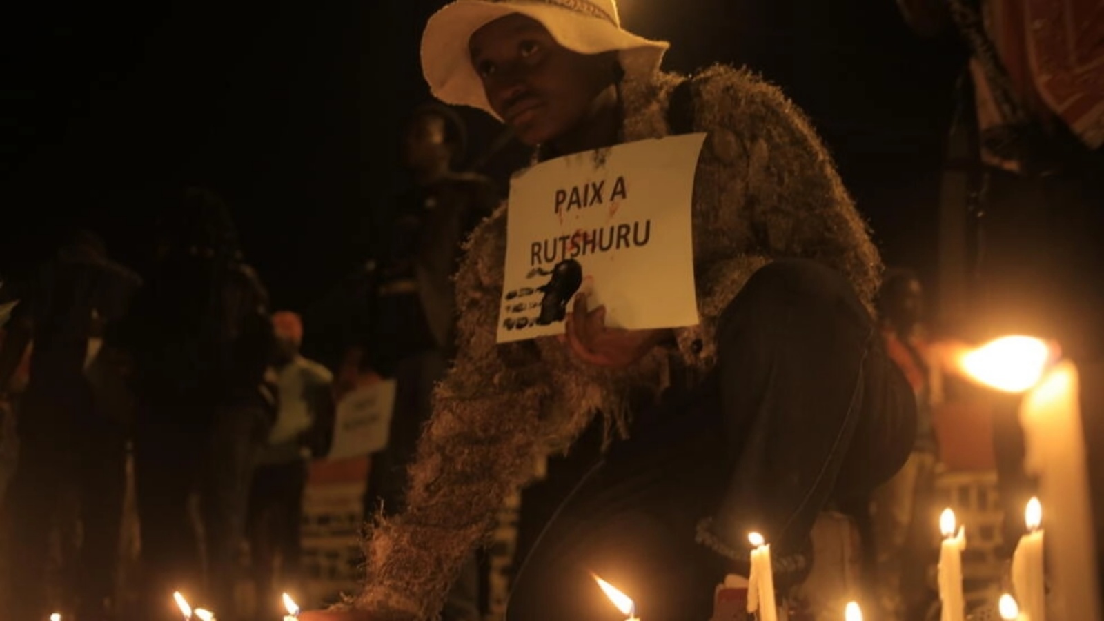 امرأة تضع شمعة لضحايا العنف خلال وقفة احتجاجية في شرق جمهورية الكونغو الديموقراطية في 7 ديسمبر 2022 في بيني