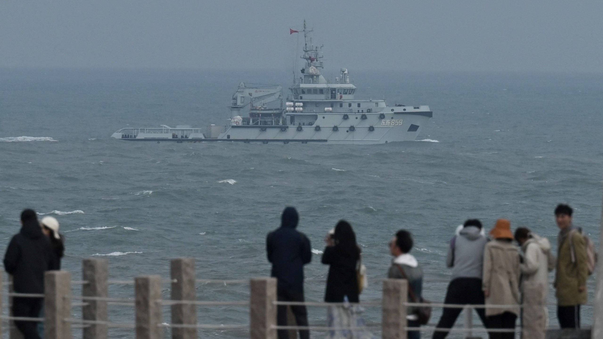 يبحر زورق قطر بحري تابع لجيش التحرير الشعبي الصيني في مضيق تايوان ، ويمر بالسائحين في جزيرة بينغتان ، وهي أقرب نقطة لتايوان ، في مقاطعة فوجيان جنوب شرق الصين