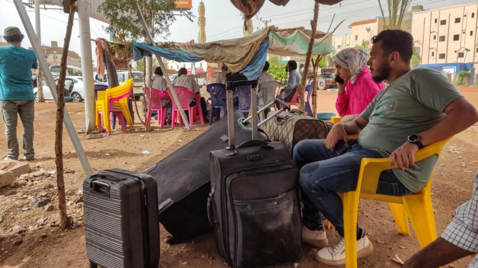 أشخاص ينتظرون مع امتعتهم للصعود إلى حافلة في جنوب الخرطوم في 24 أبريل 2023 هربا من املعارك بين الجيش وقوات الدعم السريع