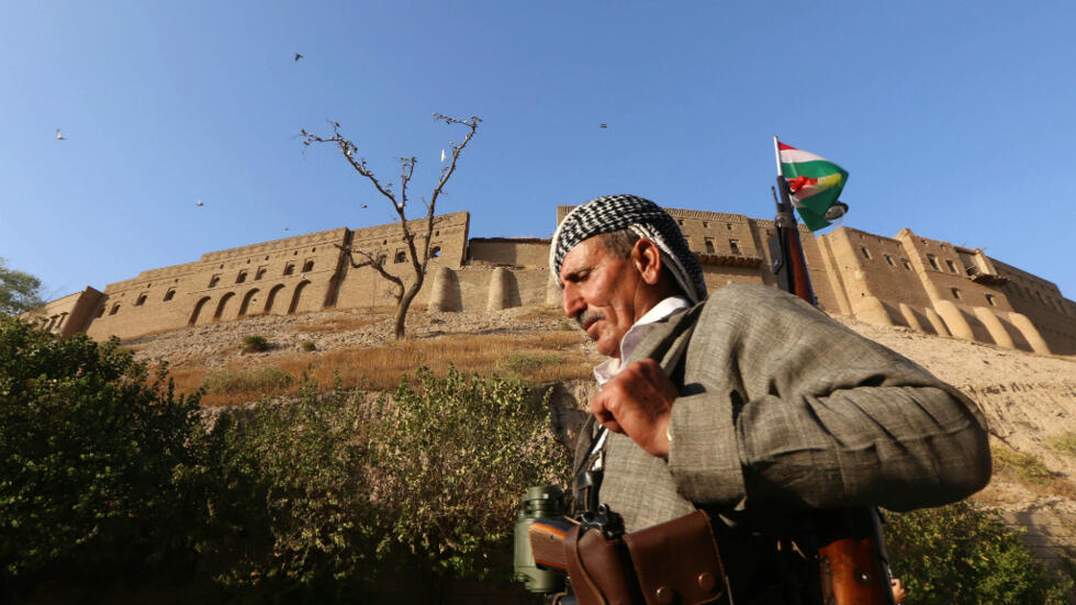 مقاتل كردي يمر من أمام قلعة أربيل