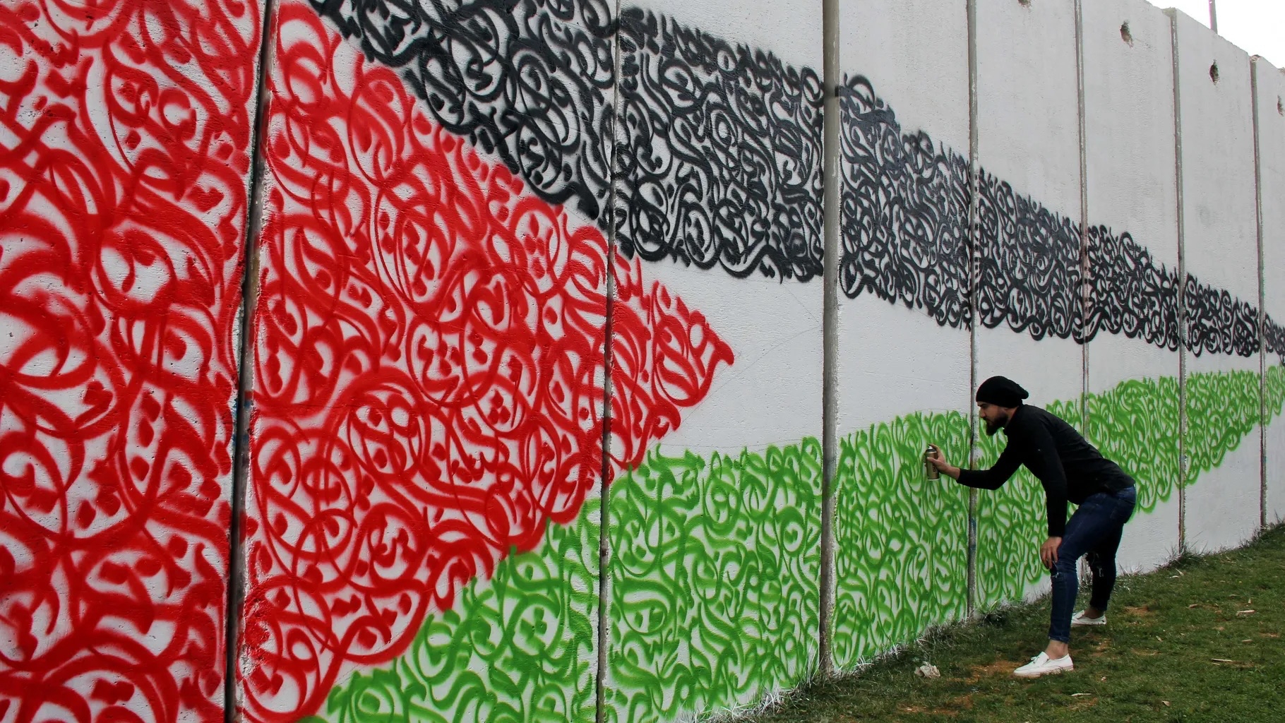 لبناني يرسم علم فلسطين على البوابة الحدودية بين لبنان وإسرائيل، في 17 كانون الأول (ديسمبر) 2017