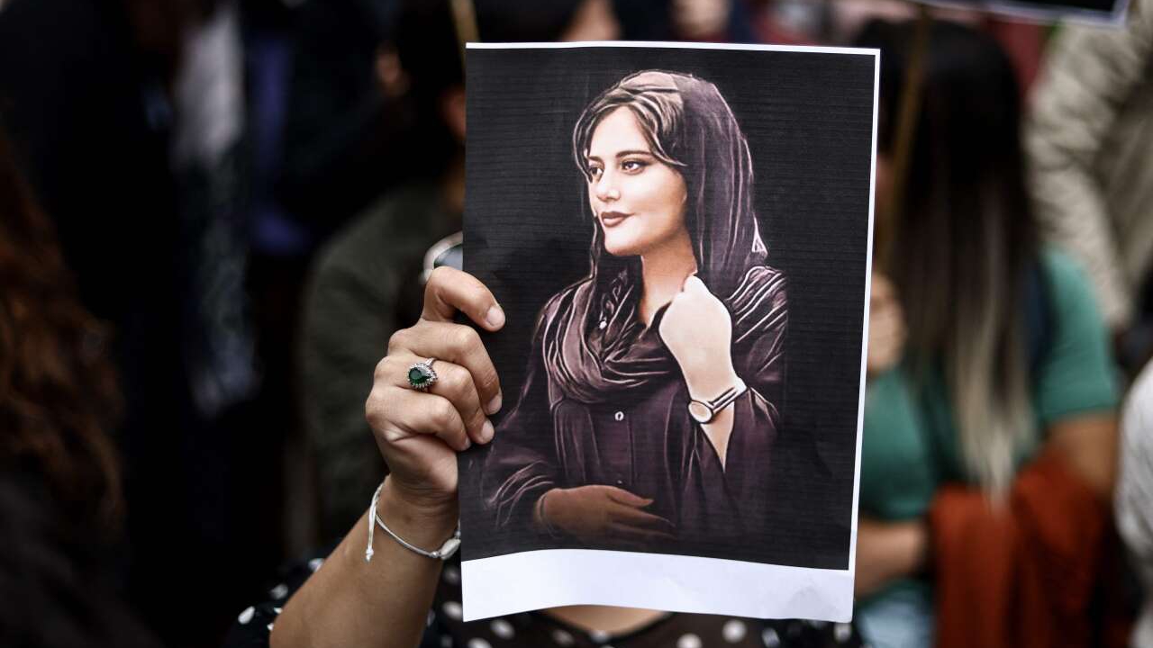 صورة مهسا أميني ترفعها امرأة خلال تظاهرة أمام سفارة إيران في بروكسل في 23 أيلول (سبتمبر) 2022