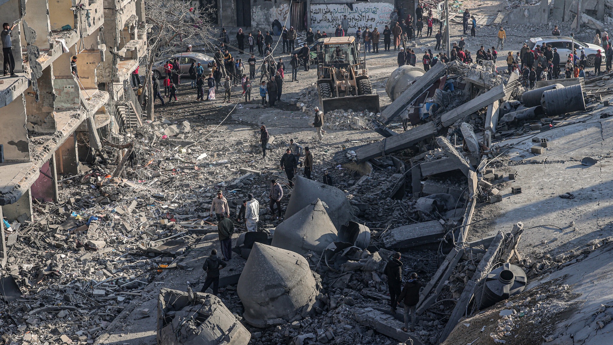 فلسطينيون بالقرب من ركام مسجد الفارق الذي تهدم بفعل غارة إسرائيلية في 22 شباط (فبراير) 2024