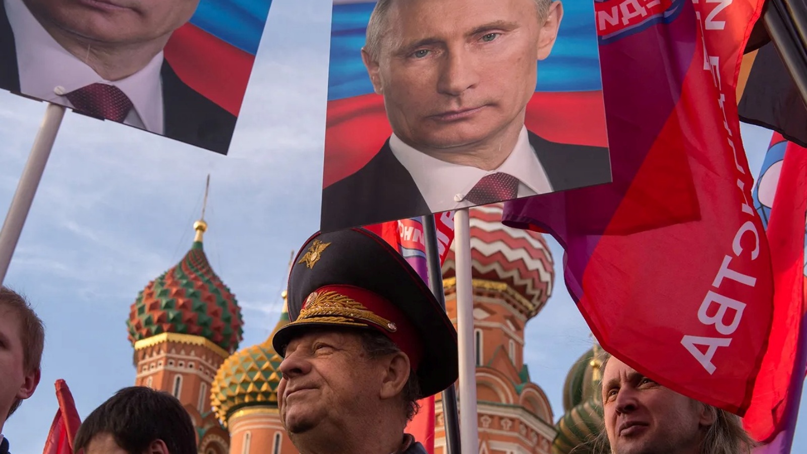 مواطنون روس يرفعن صور بوتين في الحملة الانتخابية الرئاسية 