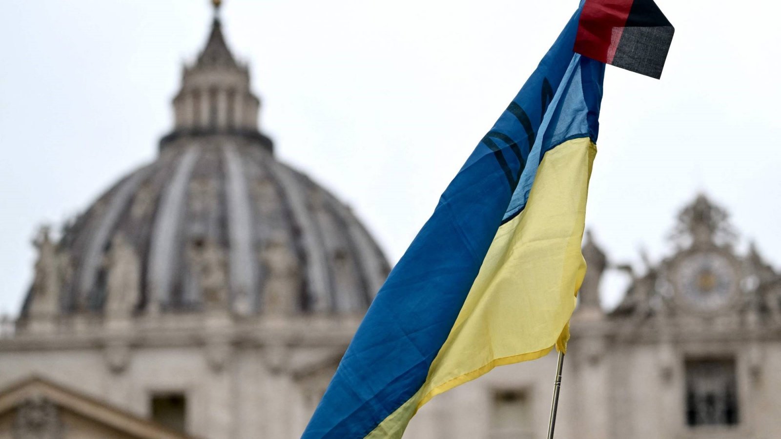 علم أوكراني يرفرف في ساحة القديس بطرس بينما يلقي البابا فرنسيس عظته في الفاتيكان الأحد 