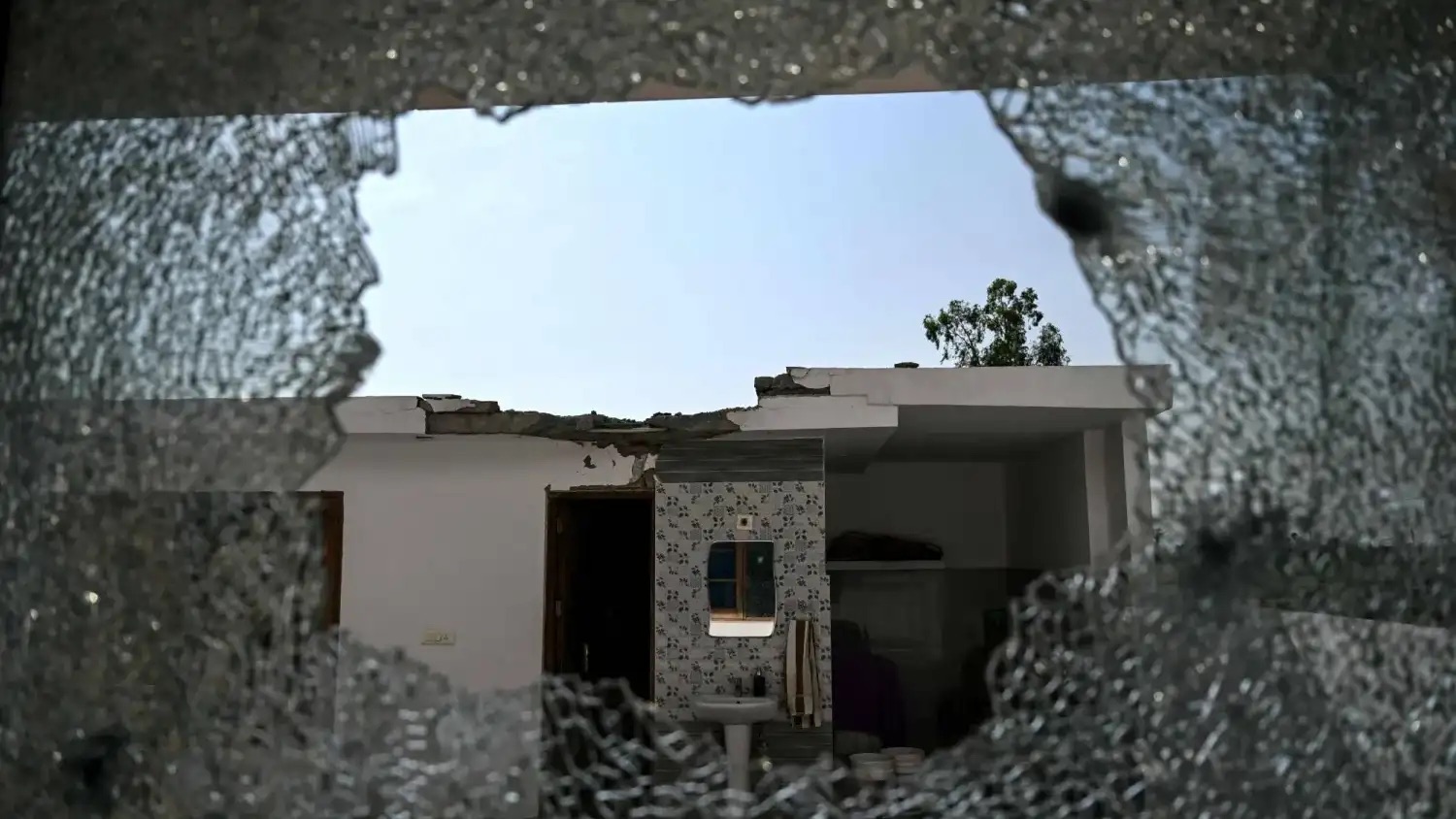 نافذة منزل محطمة في إقليم جامو الهندي نتيجة القصف عبر الحدود بين الهند وباكستان