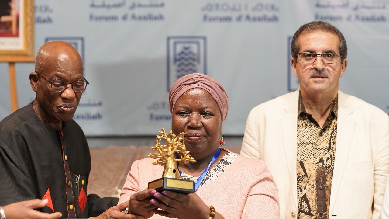 تانيلا بوني حاملة درع الجائزة وهو عبارة عن مجسم لشجرة الباو باو ويبدو إلى جانبها الشاعر السنغالي محمد لامين صال رئيس لجنة تحكيم الجائزة