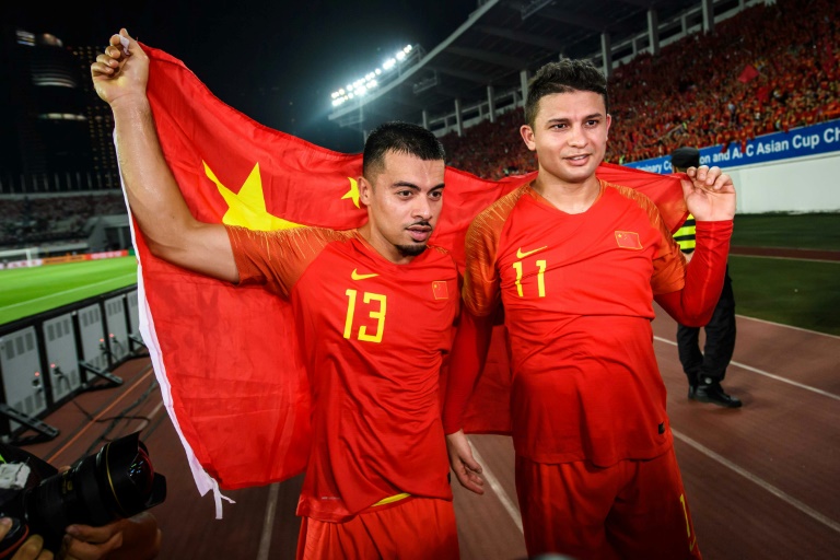 لاعبا المنتخب الصيني لي كي (يسار) والبرازيلي الاصل إلكيسون يحتفلان بالفوز على غوام في تصفيات مونديال 2022 في غوانغجو في 10 تشرين الأول/أكتوبر 2019.
