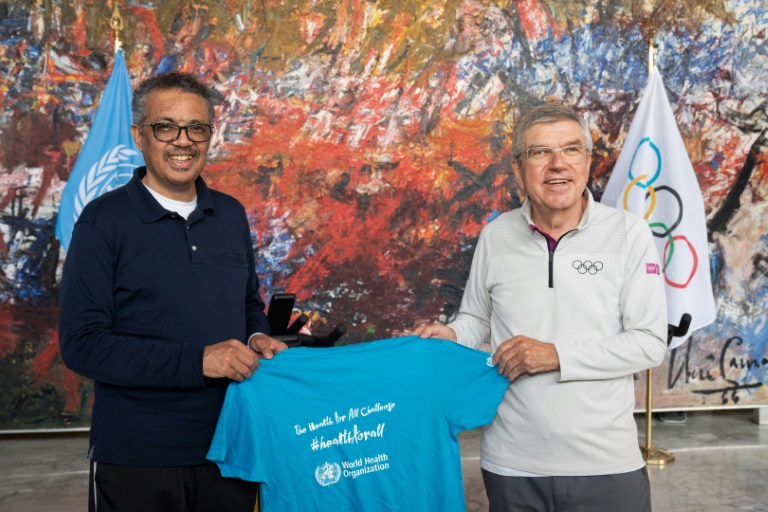 رئيس اللجنة الأولمبية الدولية الألماني توماس باخ (يمين) مع رئيس منظمة الصحة العالمية تيدروس أدهانوم غيبريسوس قبل توقيع مذكرة تفاهم بين المنظمتين للترويج لمجتمع صحي من خلال الرياضة، في 16 أيار/مايو 2020.
