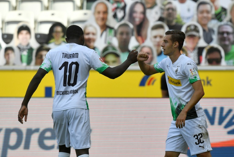 فلوريان نويهاوس يحتفل مع زميله الفرنسي ماركوس تورام بتسجيل الهدف الأول لفريق بوروسيا مونشنغلادباخ في مرمى أونيون برلين في المرحلة 29 من الدوري الألماني لكرة القدم. 