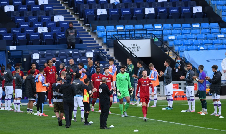 لاعبو ليفربول يدخلون أرض ملعب الاتحاد على وقع تحية لاعبي مانشستر سيتي قبل بداية مباراة الفريقين ضمن الدوري الإنكليزي الممتاز لكرة القدم، في الثاني من تموز/يوليو 2020.