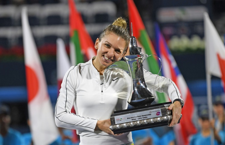 نجمة كرة المضرب الرومانية سيمونا هاليب تحمل كأس دورة دبي بعد تغلبها على الكازاخستانية ايلينا ريباكينا في 22 شباط/فبراير الماضي.