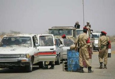  جنود يراقبون السيارات في نقطة تفتيش قرب الحدود السعودية