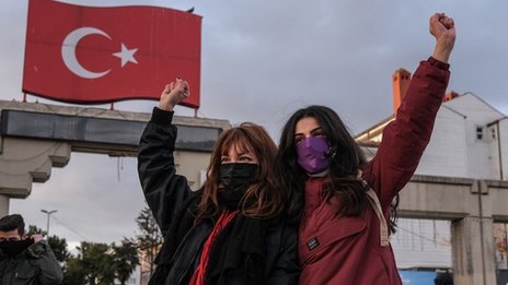 متظاهرتان وخلفهما العلم التركي