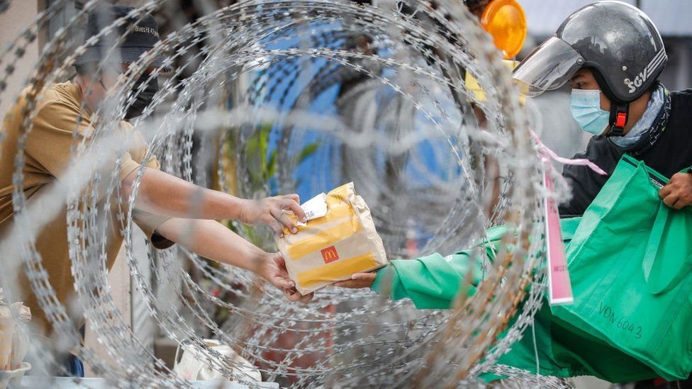 Getty Images ماليزي يتلقى غذاء في منطقة وضعت قيد تدابير إغلاق صارمة