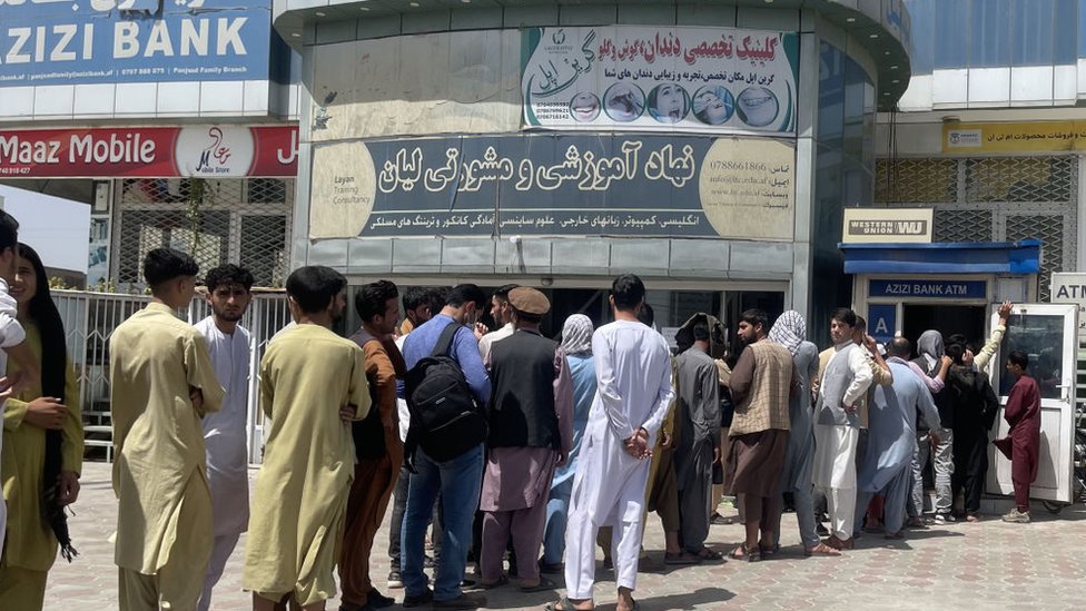 Getty Images أفغان يصطفون خارج بنك لسحب أموال وسط أزمة مالية في كابل