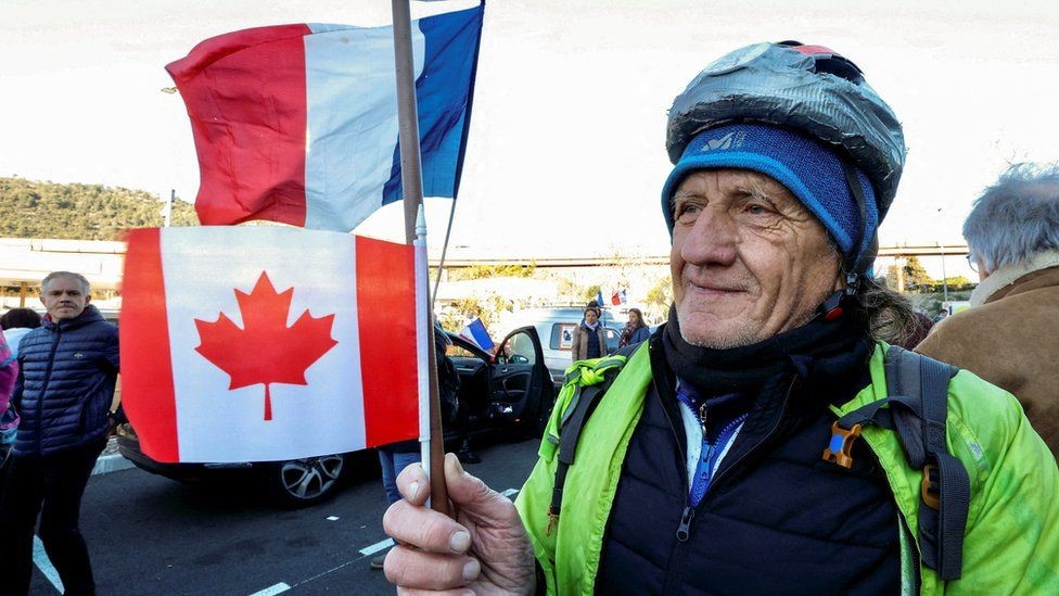 Reuters ناشط في نيس يلوح بالعلم الفرنسي والكندي قبل انطلاق قافلة إلى باريس الأربعاء