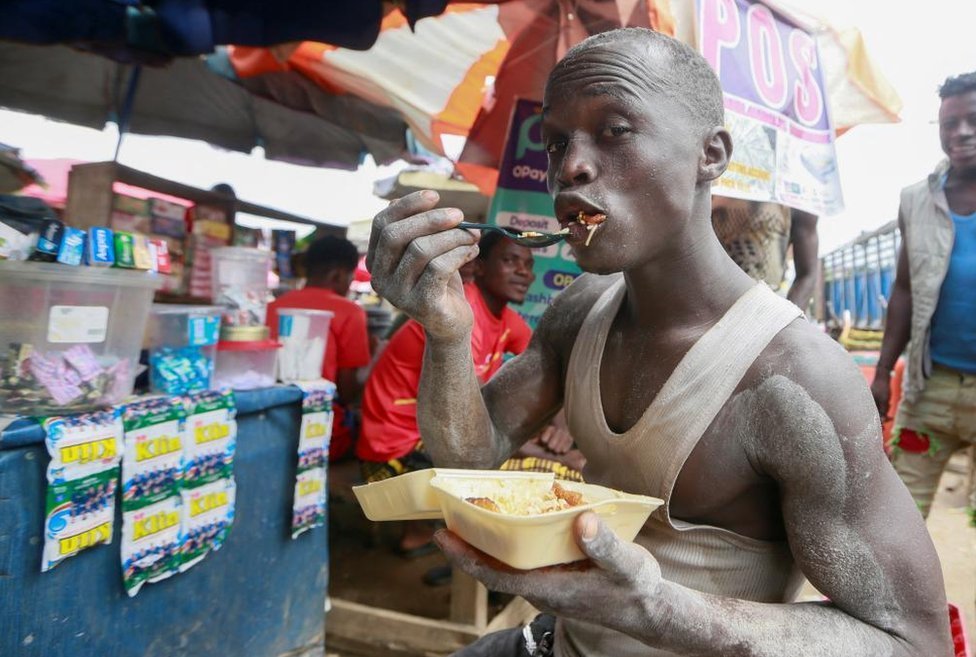 Reuters هذا الرجل يستمتع بتناول الأرز وموز الجنة في أحد الأسواق في العاصمة النيجيرية أبوجا