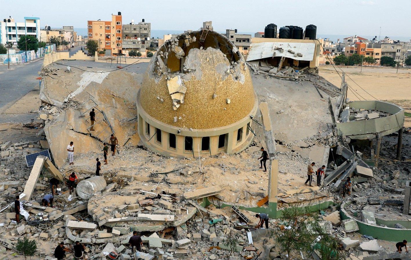 Reuters فلسطينيون يتفقدون مسجدا دمرته غارات إسرائيلية في خان يونس جنوب قطاع غزة.