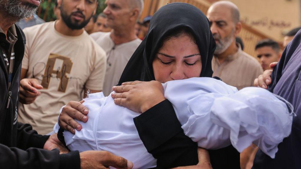 Getty Images | أم تحتضن رضيعها ذا الثمانية أشهر الذي قتل في غارات إسرائيلية على مدينة خان يونس في 28 أكتوبر/تشرين الأول