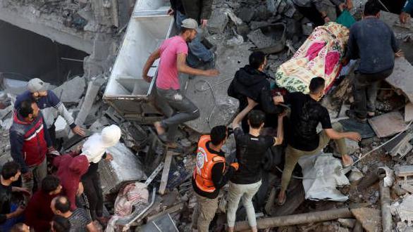 Getty Images رجال الدفاع المدني ومواطنون فلسطينيون ينتشلون جثة من بين حطام أحد المنازل في مخيم رفح بعد تجدد القصف الإسرائيلي على قطاع غزة