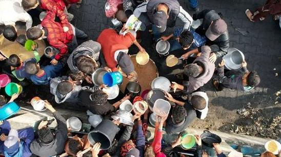 REUTERS | فلسطينيون يتجمعون حول نقطة توزيع الغذاء في رفح